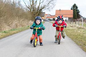 Abbildungen: Zwei Jungen auf ihren Laufrädern
